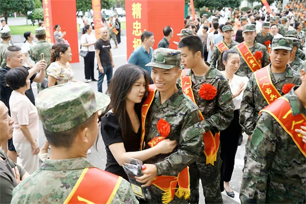 图5“准新兵”陈文涛拿着家人送的袜子与恋人相拥的画面被抓拍.jpg